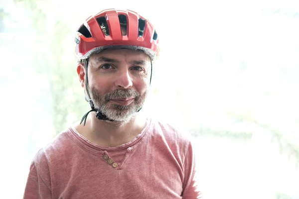 カメラを見て笑顔のサイクリストの肖像画 バックライト 彼は赤いヘルメットを着ている 道路の概念の安全と保護 — ストック写真