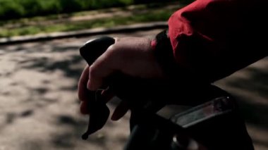 Fren kolu freni kullanarak yakın plan el. Sessiz yolda giderken, bazı bulanık insanlar egzersiz yapıyor. Spor ve güvenlik kavramı.