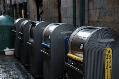 Row of modern public recycling bins standing on a city street, encouraging responsible waste disposal and promoting environmental sustainability within urban areas clipart