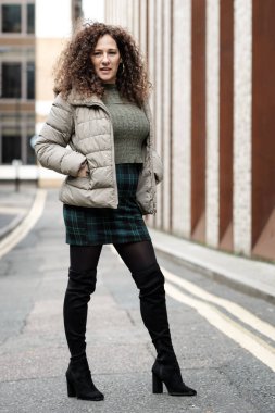 Soğuk bir kış gününde Londra sokaklarında poz veren kendinden emin olgun bir kadın..