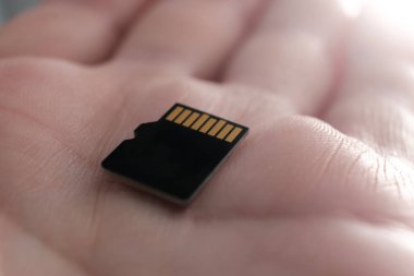 Avucundaki küçük mikro SD kartın resmini kapat. Dijital cihazlar için ekstra depolama. Makro görüntü, sadece avuç içini görebiliyoruz..