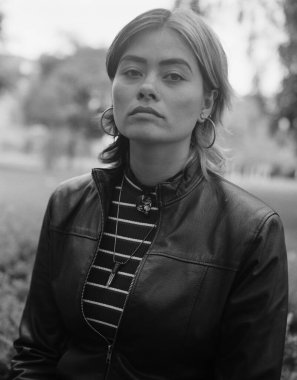 Açık havada kameraya bakan genç melez bir kadının klasik monokrom portresi. Rahatlamış ve kendinden emin görünüyor ve bir parkta. Film analog ortam biçimi kamera.