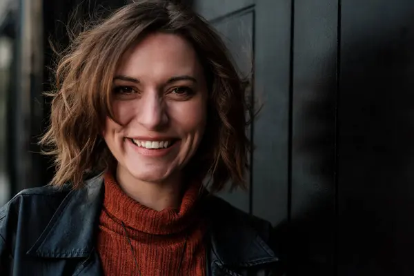 Kameraya bakan doğal bir kadının dürüst vesikalığı. Gülümsüyor ve mutlu görünüyor..