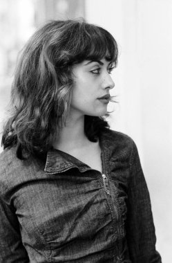 Dışarıya bakan genç bir kadının siyah beyaz portresi. O bir kot ceket giyiyor. Görüntü analog bir film kamerasıyla yapıldı. Eski teknolojik teknikler kavramı.