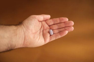 Tek bir hap gösteren, ilaç, sağlık ve ilaç temalarını vurgulayan ve aynı zamanda sağlık ve hasta bakımının önemini vurgulayan açık bir el yazısı