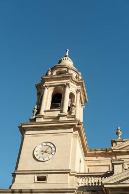 Pamplona katedralinin çan kulesi, İspanya, berrak mavi gökyüzüne karşı dimdik duruyor, karmaşık mimarisini ve saatini gözler önüne seriyor.
