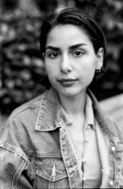 Kot ceket giyen ve kısa saçlı, 35 mm 'lik klasik bir estetik filmle çekilen, zamansız bir his yaratan tek renkli bir kadın portresi.