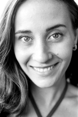 Görünür film tahıllarıyla gülümseyen genç bir kadının tek renkli analog portresi 35 mm 'lik film fotoğrafçılığını andırıyor.