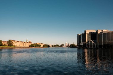 Güneş ışığı, gündoğumunda Londra rıhtımındaki Millwall rıhtımının sakin sularına yansıyan modern binaları aydınlatarak huzurlu ve manzaralı bir şehir manzarası yaratıyor.