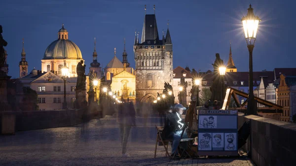 Esnaf, geceleyin Charles Köprüsü, Prag ve Çek Cumhuriyeti 'nde tarihi eser üzerine çizim yapıyor..