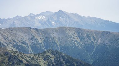 Prominent mountain range peak towering above layers of smaller mountains, EU, Slovakia.