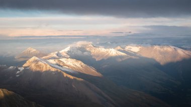 Renkli günbatımında karla kaplı zirveleri olan görkemli dağ sıraları, Avusturya Alpleri, Avrupa.