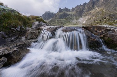 Ön planda şelale ve arka planda kayalık tepeler, Slovakya, Avrupa.