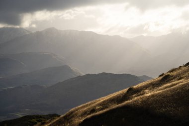 Yeni Zelanda 'daki dağların yamaçlarına vuran akşam ışığının dar görüntüsü..