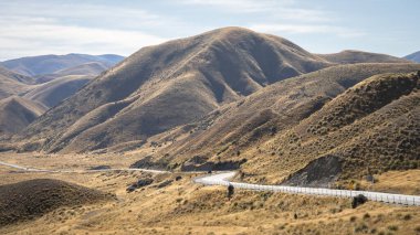 Lindis Geçidi, Yeni Zelanda 'da sonbahar renkleriyle yüksek dağ geçidine giden kıvrımlı bir yol..