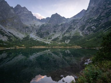 Renkli günbatımında dağlarla çevrili güzel dağlık göl, Avrupa ve Slovakya.