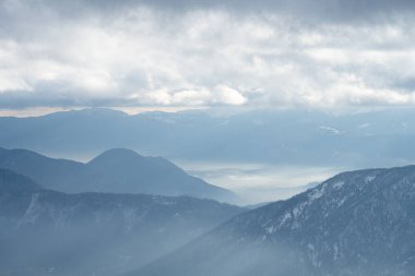 Kış manzarası, bulutlu vadilerde gizlenmiş dağ sıraları bulutlu bir günde.