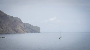 Sahil kayalıkları yakınında küçük yelkenli, Madeira, Portekiz.