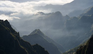 Güneşin doğuşunda, Madeira, Portekiz 'de ilk güneş ışığını yakalayan güzel sisli dağ manzarası.