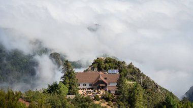 Portekiz, Madeira 'da bulutlarla kaplı dağın zirvesinde bulunan dağ kulübesine bakın..