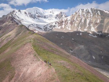 Karlı Pamir Dağları 'na, Kırgızistan' a doğru yürüyen dağcılarla Alp Dağları manzarası.