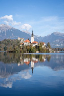Gölün ortasındaki kilisenin dikey çekimi, arka planda şato, Bled, Slovenya, Avrupa.
