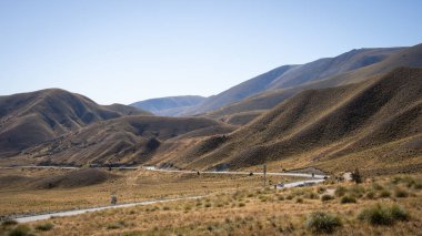 Ağaçsız tepe vadisinden geçen otoban, Lindis Geçidi, Yeni Zelanda.