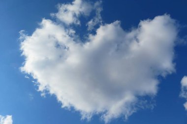 Mavi gökyüzü arka planında kalp şekli bulutu, doğal bulutlar