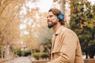 Parkta müzik dinleyen beyaz bir adamı yakından izleyin. Yüksek kalite fotoğraf.