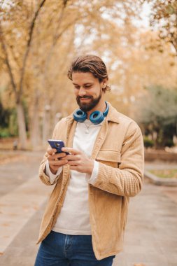 Parkta cep telefonu kullanan beyaz bir adam. Yüksek kalite fotoğraf.