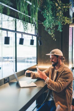 Kafedeki beyaz adam kahve ve dizüstü bilgisayarının fotoğrafını yolluyor. Yüksek kalite fotoğraf.