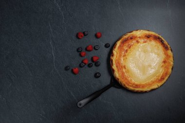 Basque cheesecake with blueberries and raspberries, copy space, overhead view. High quality photo