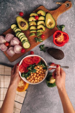 Etrafı sebzelerle çevrili bitkilerle dolu sağlıklı bir kase. Kadın elleri kaseyi tutuyor. Yüksek kalite fotoğraf
