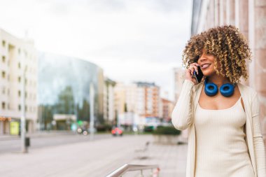 Urban Connectivity: Afro Woman Walking, ve telefonuyla konuşuyor. Yüksek kalite fotoğraf