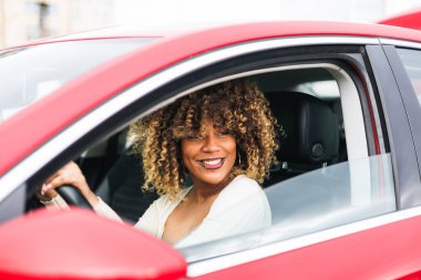 Kırmızı arabalı, kendine güvenen Afro-Dominik kızı, gülen surat. Yüksek kalite fotoğraf