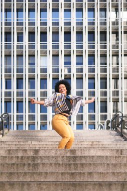 Afrikalı kadın modern merdivenlerde mutlu dans ediyor. Yüksek kalite fotoğraf
