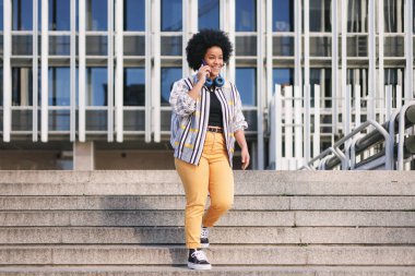 Bin yıllık afro kadın merdivenlerde telefonuyla konuşuyor. Yüksek kalite fotoğraf