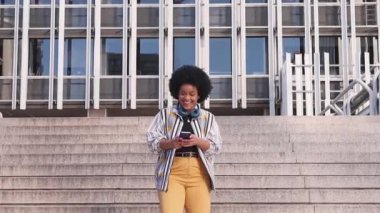 Bin yıllık afro kadın merdivenlerde telefonuyla konuşuyor. Yüksek kalite fotoğraf