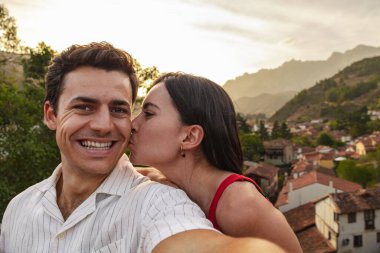 Dağ köyünde kendine yeten sevimli bir çift. O onu öpüyor. Romantik kaçış konsepti. Yüksek kalite fotoğraf