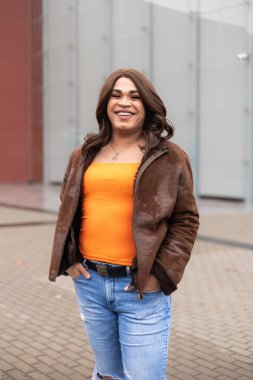 Başarılı ve kendinden emin trans kadın kameraya mutlu bir şekilde gülümsüyor. Latin kökenli. Yüksek kalite fotoğraf