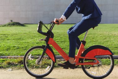 Modern parkta resmi kıyafetli bir adamın elektrikli bisiklet sürüşü. Yüksek kalite fotoğraf