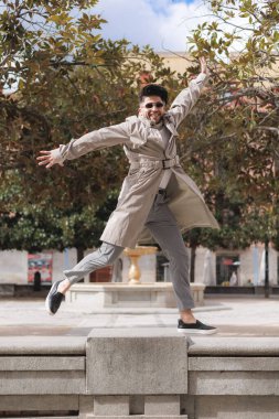 Havalı Latin adam parkta heyecandan zıplıyor. Yüksek kalite fotoğraf