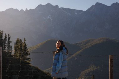 Dağlık arazide kameraya bakan genç bir kadın. Yürüyüş, yürüyüş, dağcılık. Yüksek kalite fotoğraf