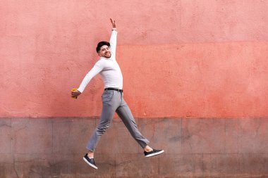 Z jeneratörü atlıyor ve pembe bir arka plan üzerinden kameraya bakıyor. Yüksek kalite fotoğraf