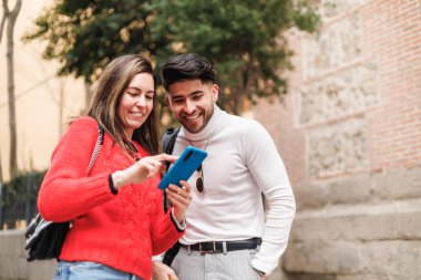 Z jenerasyonu arkadaşları cep telefonu kullanıyor ve sokakta yürüyor. Yüksek kalite fotoğraf