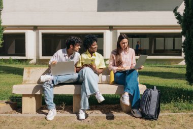 Üniversite kampüsünde öğrenciler dizüstü bilgisayar ve tablet kullanıyorlar. Üniversite, teknoloji, ödev. Yüksek kalite fotoğraf