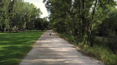 Şehir parkında koşan atletik bir adam. Kamera geriye doğru gidiyor. Uzayı kopyala - Evet. Yüksek kalite 4k görüntü