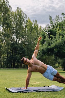 Halk parkında hasırla egzersiz yapan genç bir latin. Dikey kopyalama alanı. Yüksek kalite fotoğraf