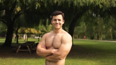 Kollarını kavuşturup kameraya gülümseyen genç güçlü Latin adamın portresi. Yüksek kaliteli FullHD görüntüler