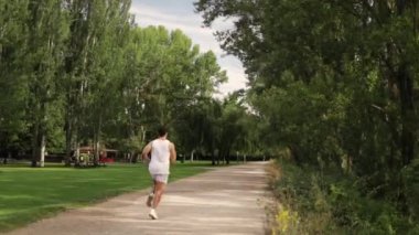 Green Park 'ta milenyum koşucusunun arka görüntüsü. Kardiyo, egzersiz, fitness konseptleri. Yüksek kaliteli FullHD görüntüler